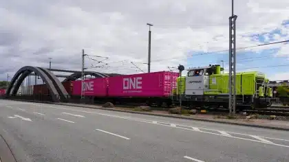 Documento di negoziazione su scrivania con vista sfocata di cantiere ferroviario e container merci sullo sfondo