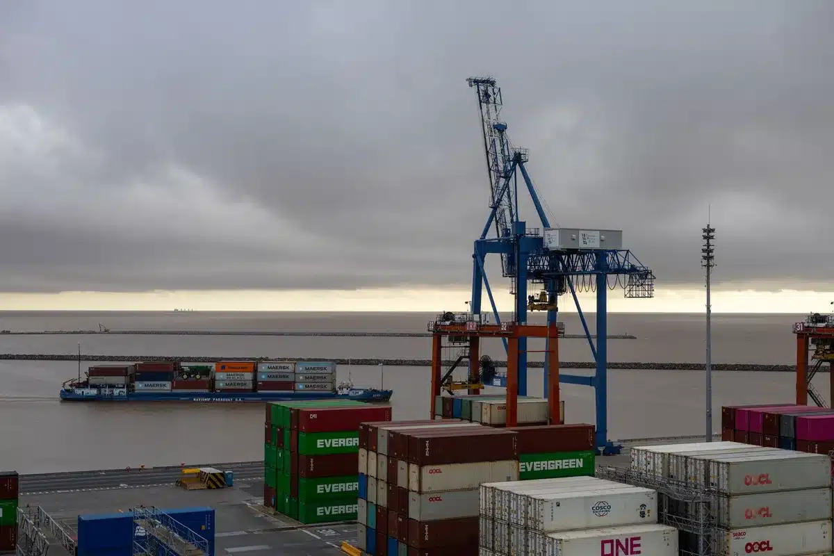 Terminale portuale con container e navi cargo al tramonto, simbolo della strategia di trasporto marittimo