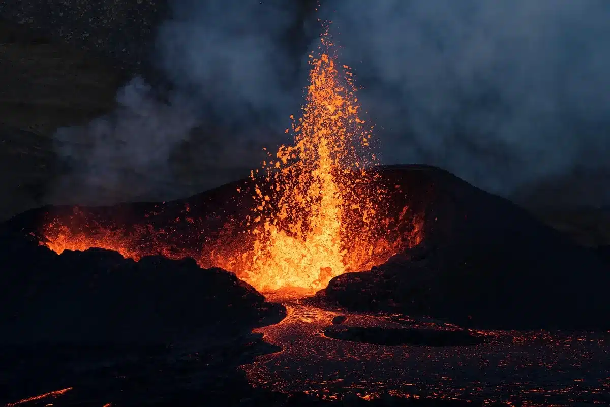 Automobile completamente ricoperta di cenere vulcanica scura con marciapiedi anneriti sullo sfondo