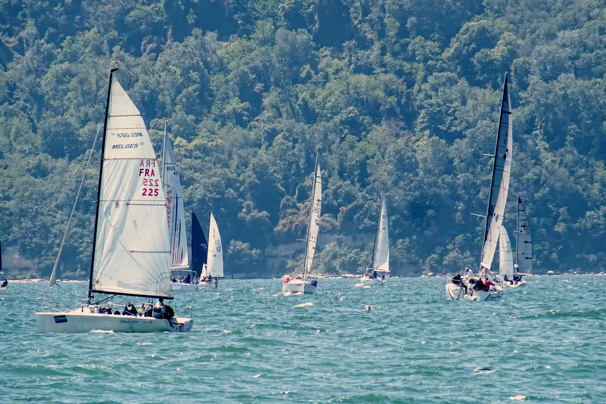 Velista in azione durante una regata con spruzzi d'acqua e luce naturale