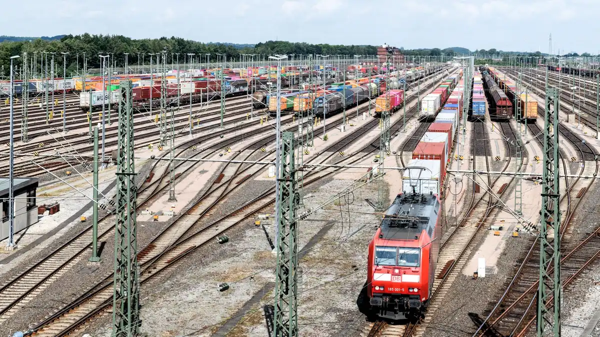 Treno merci su binario con container impilati, simbolo del trasporto intermodale