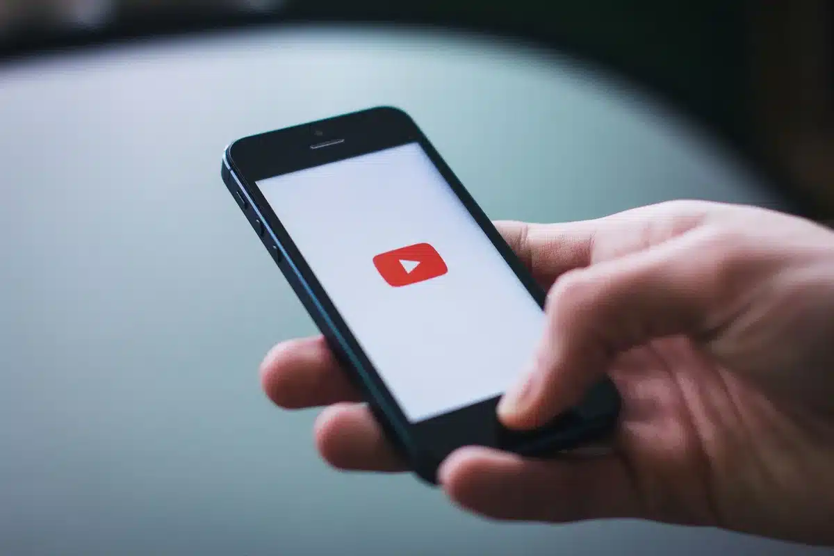 Schermo di smartphone con video in riproduzione e icone di social media