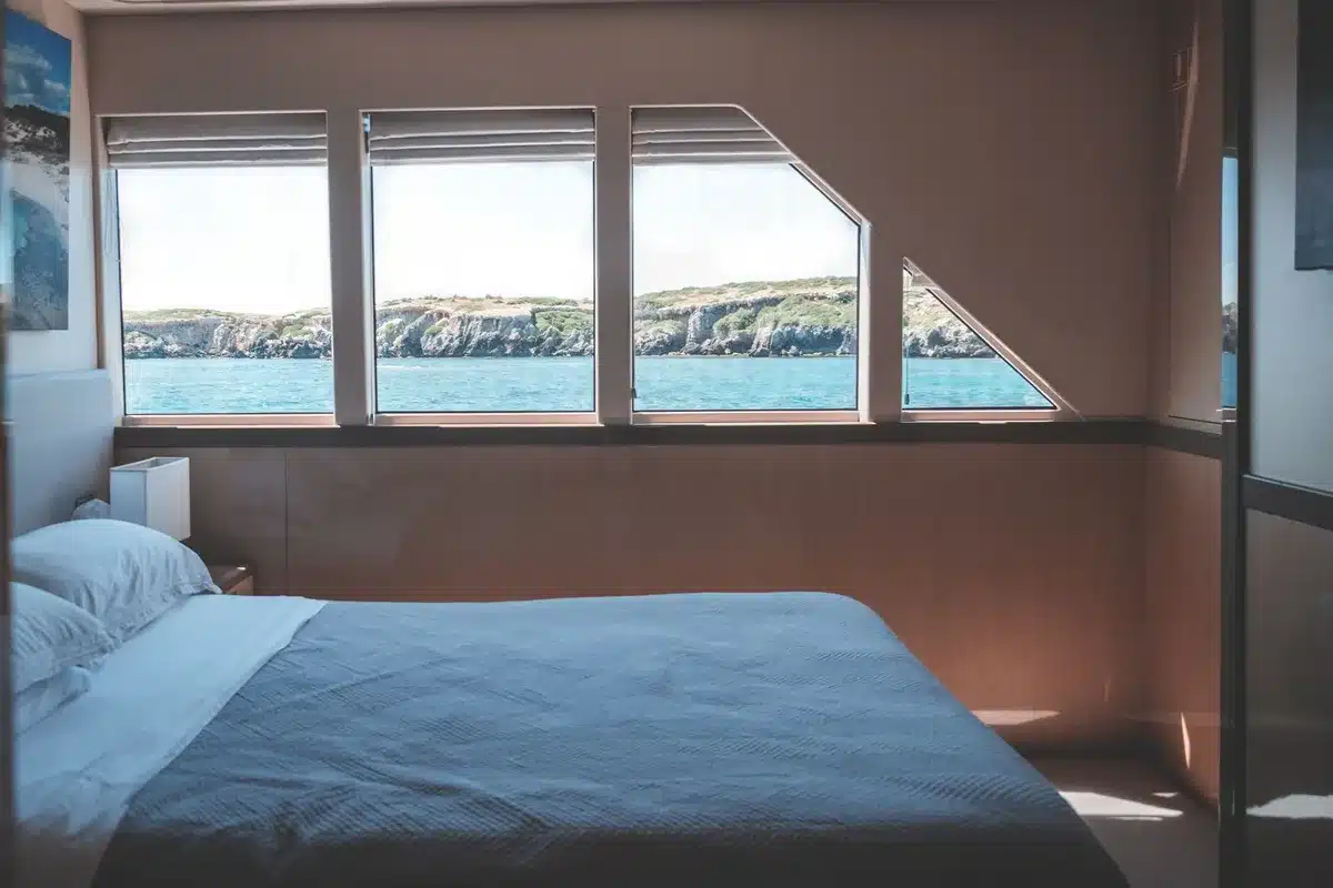Interno di una master suite di yacht con arredamento neutro e materiali pregiati