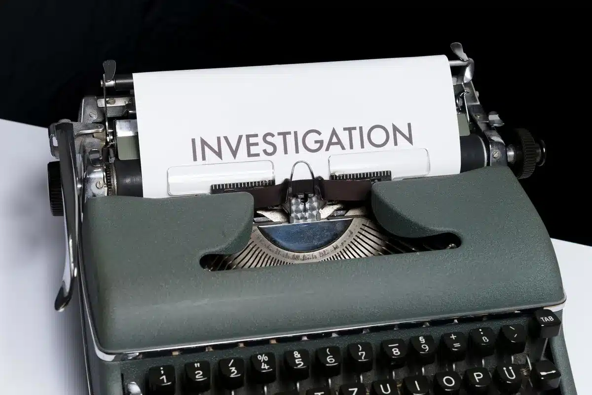 Documenti di un'indagine antitrust su una scrivania con simboli di regolamentazione