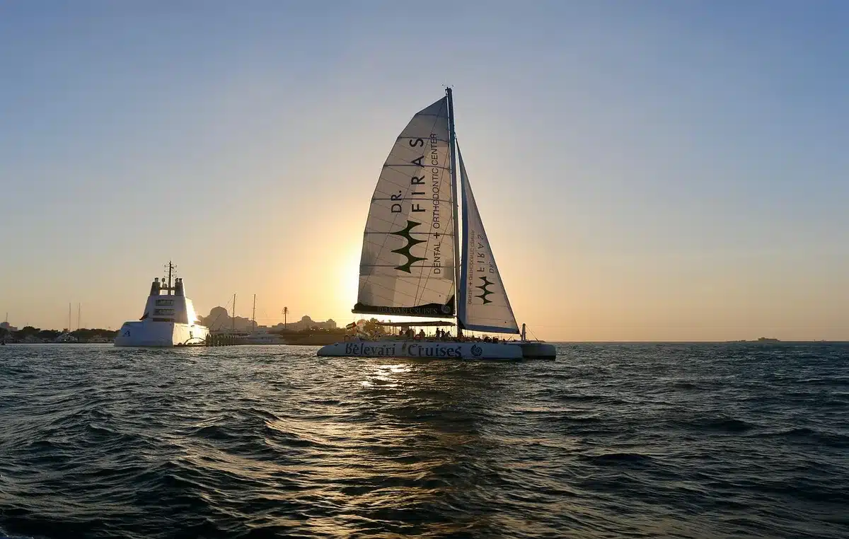 Catamarano elettrico esposto con pannelli solari e visitatori intorno