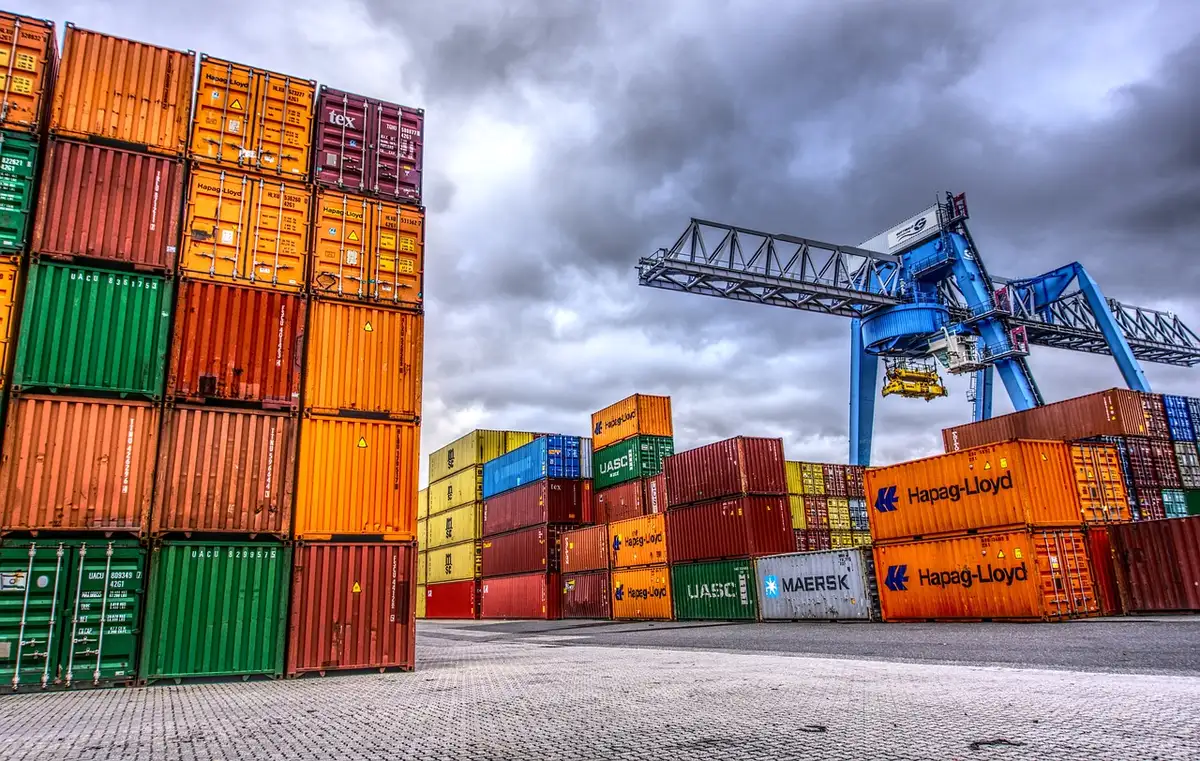 Piazzale di un terminal con container impilati e mezzi di movimentazione