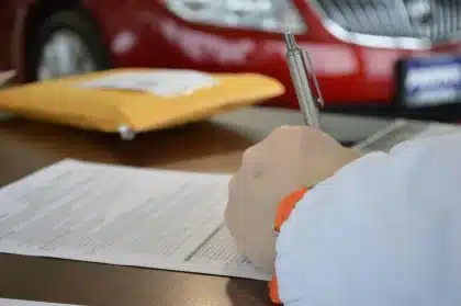 Interno di ufficio motorizzazione con scrivanie e documenti, silhouette di persona sullo sfondo