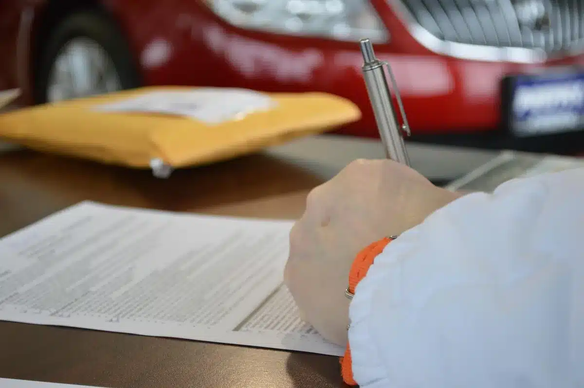 Interno di ufficio motorizzazione con scrivanie e documenti, silhouette di persona sullo sfondo