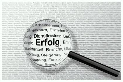 Mano con lente d'ingrandimento su documenti e schermi digitali durante una ricerca di informazioni