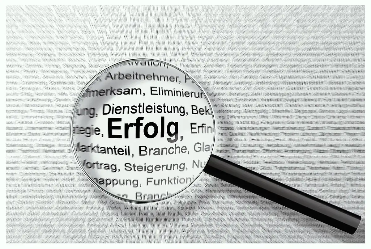 Mano con lente d'ingrandimento su documenti e schermi digitali durante una ricerca di informazioni