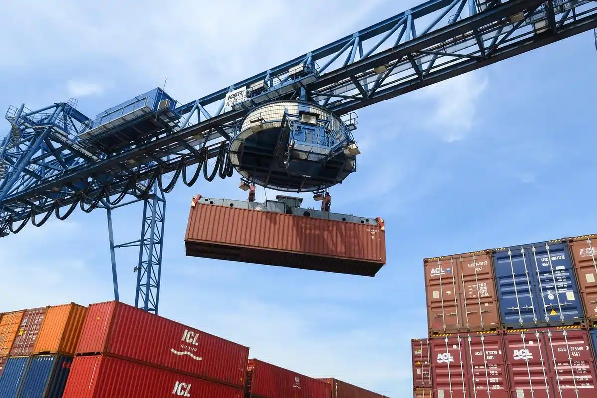 Porto commerciale con navi cargo, gru e operazioni logistiche in una città costiera toscana