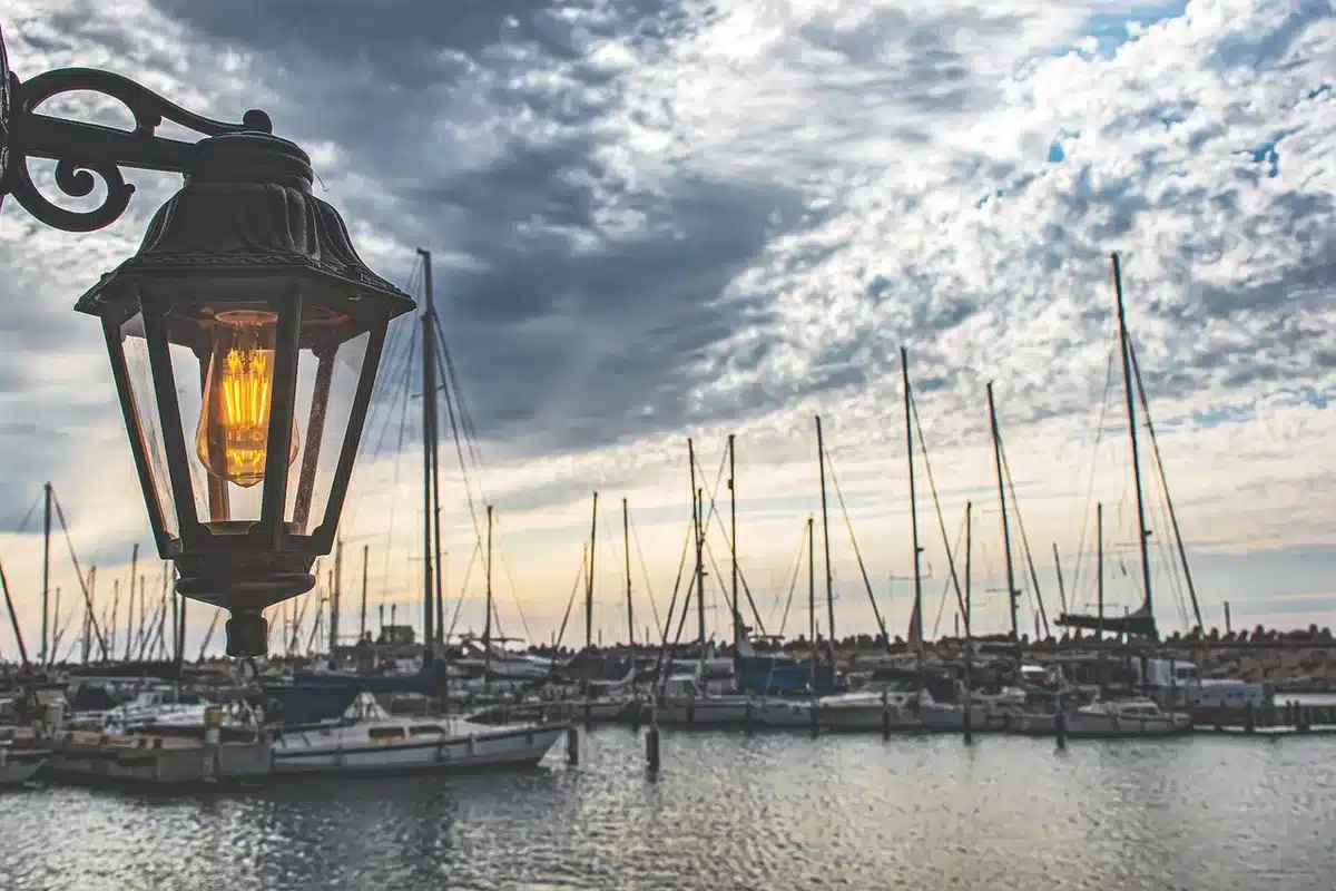 Famiglia passeggia lungo la banchina di una marina moderna con imbarcazioni ormeggiate e servizi a bordo.