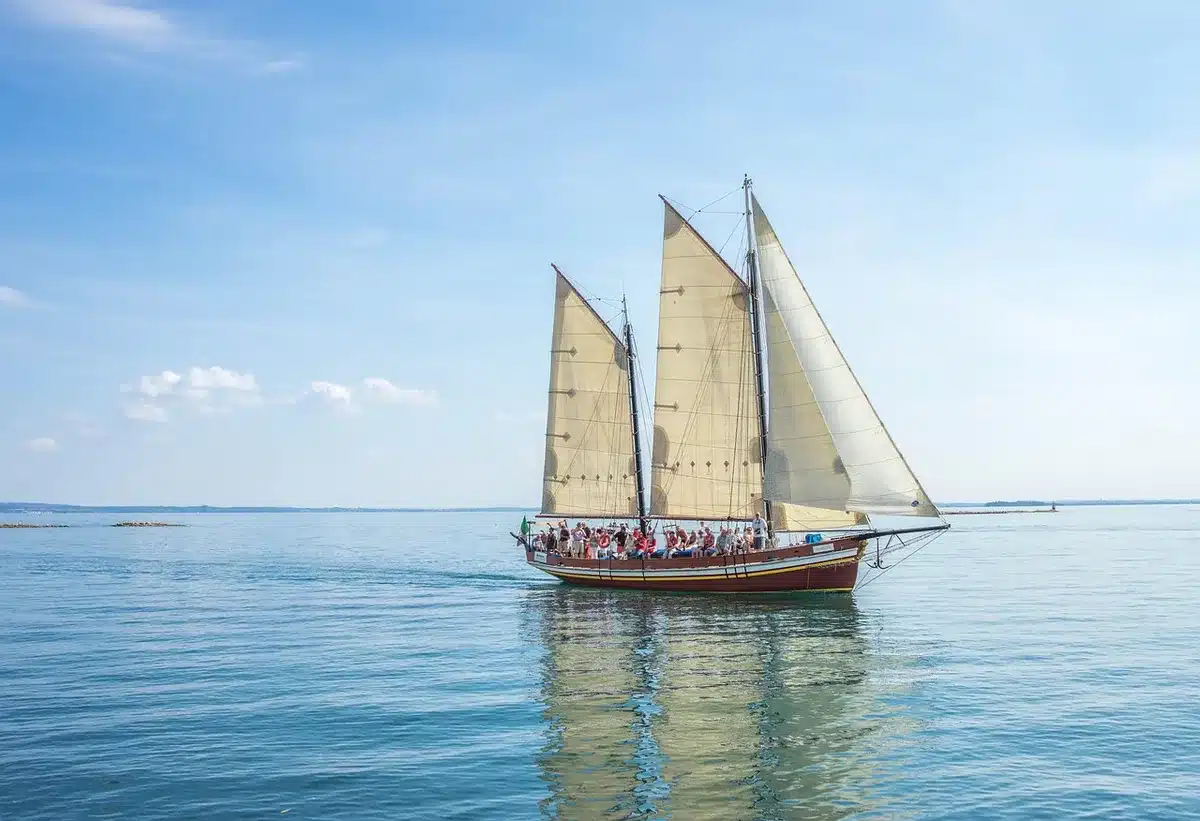 Flotta eterogenea di imbarcazioni moderne e storiche in navigazione durante una regata in mare aperto