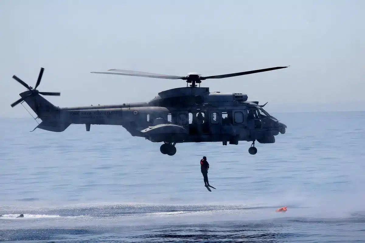 Elicottero di soccorso in volo notturno sulla costa tirrenica con luci di ricerca attive