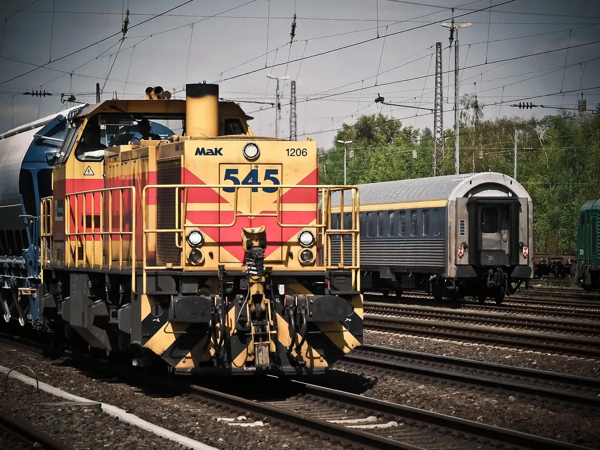 Treno merci intermodale accanto a container e terminal ferroviario