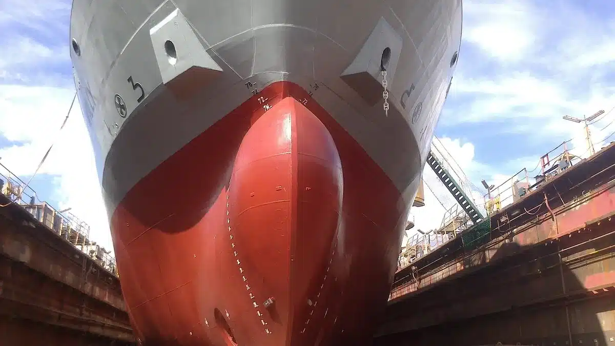 Scafo di una grande nave in bacino con gru e impalcature a Marghera, vista anonima