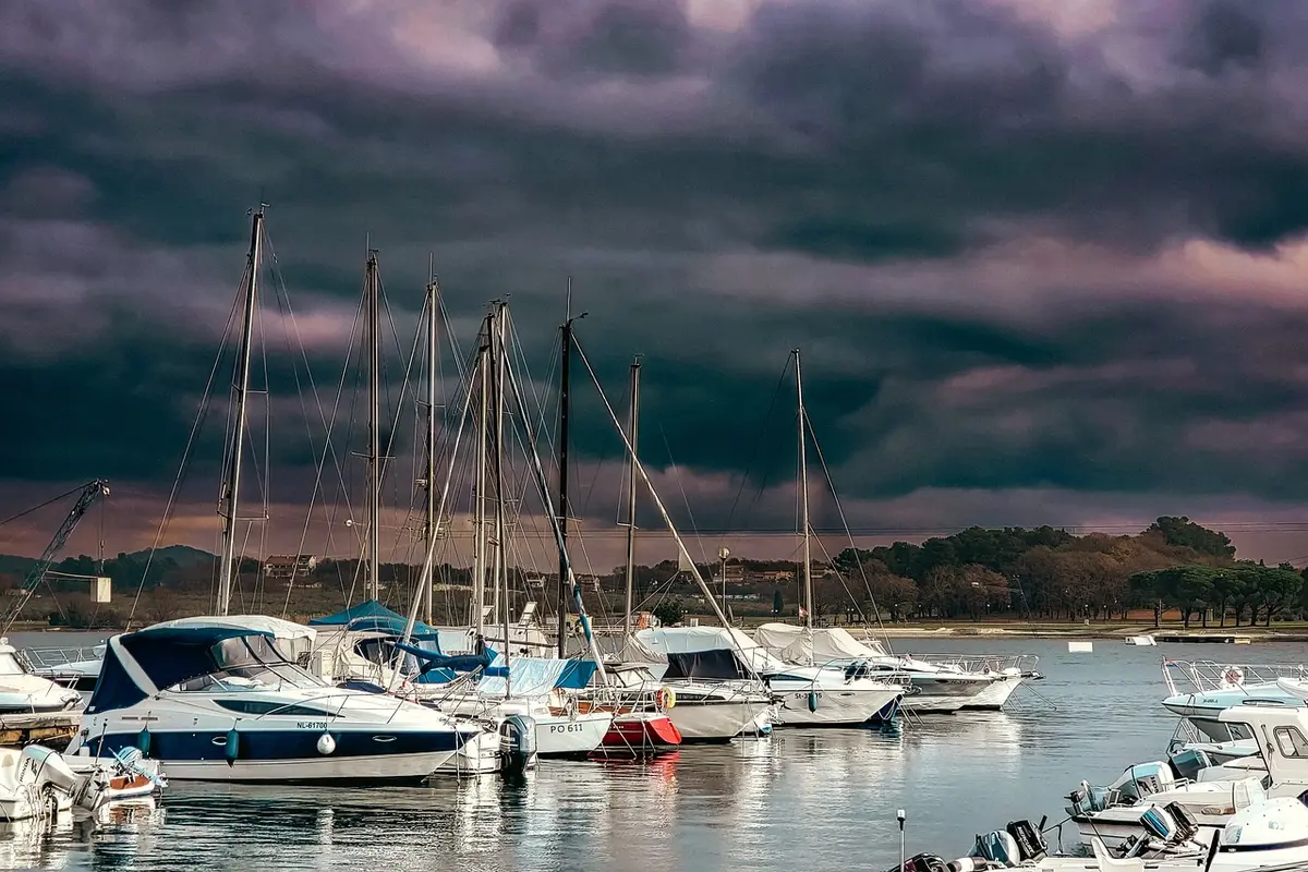 Barche esposte in acqua lungo i pontili di una marina